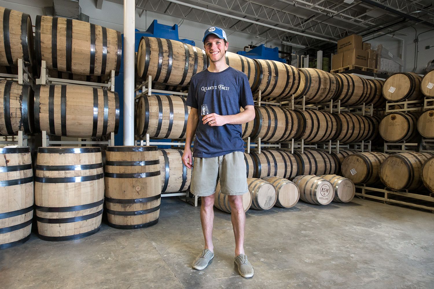 Employee Chad tasting whiskey inside the rick house.