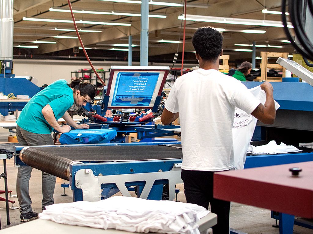 A candid shot of screen print press operators completing customer orders.