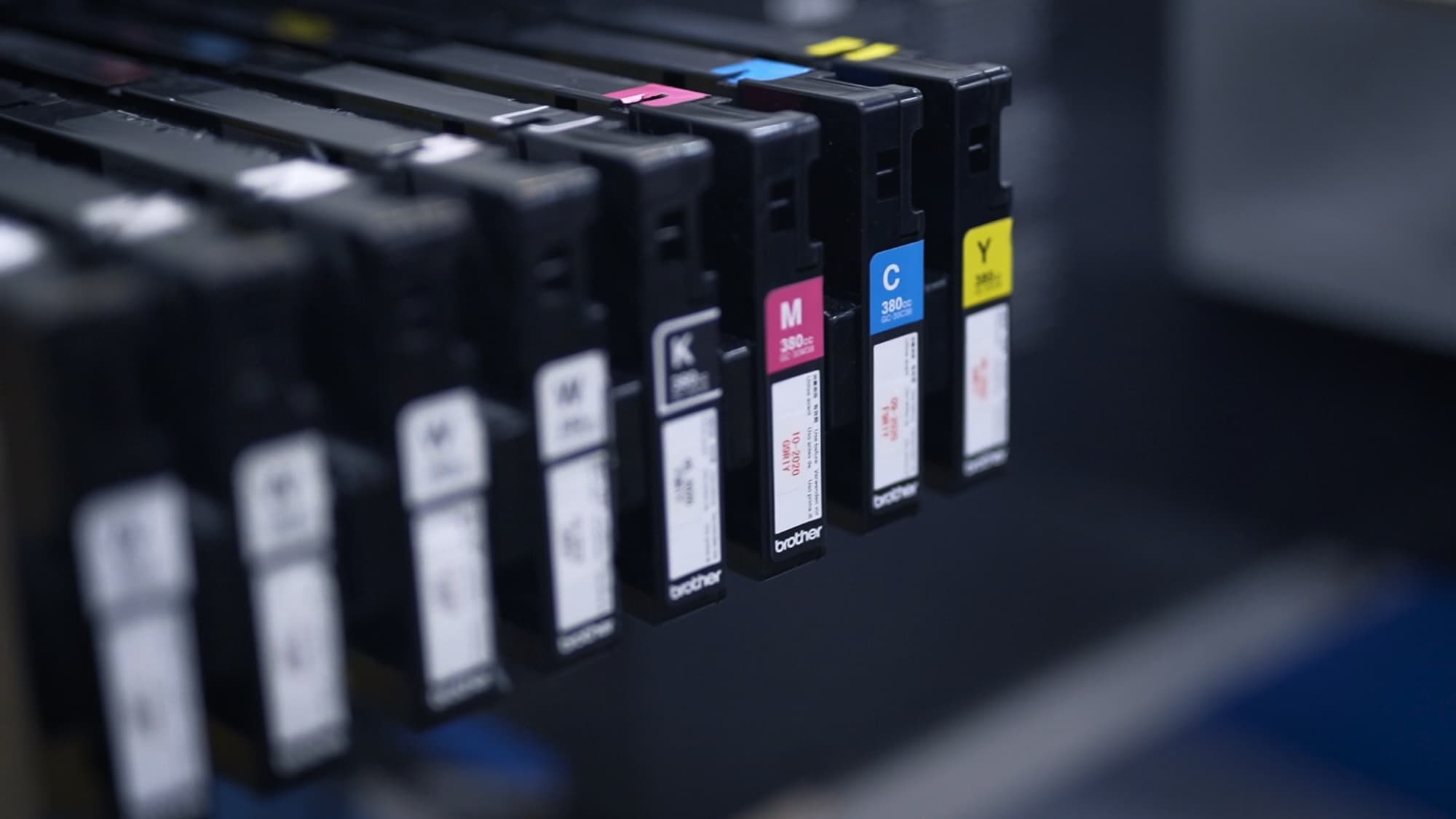 Showcasing the CMYK ink cartridges of a direct-to-garment printer.