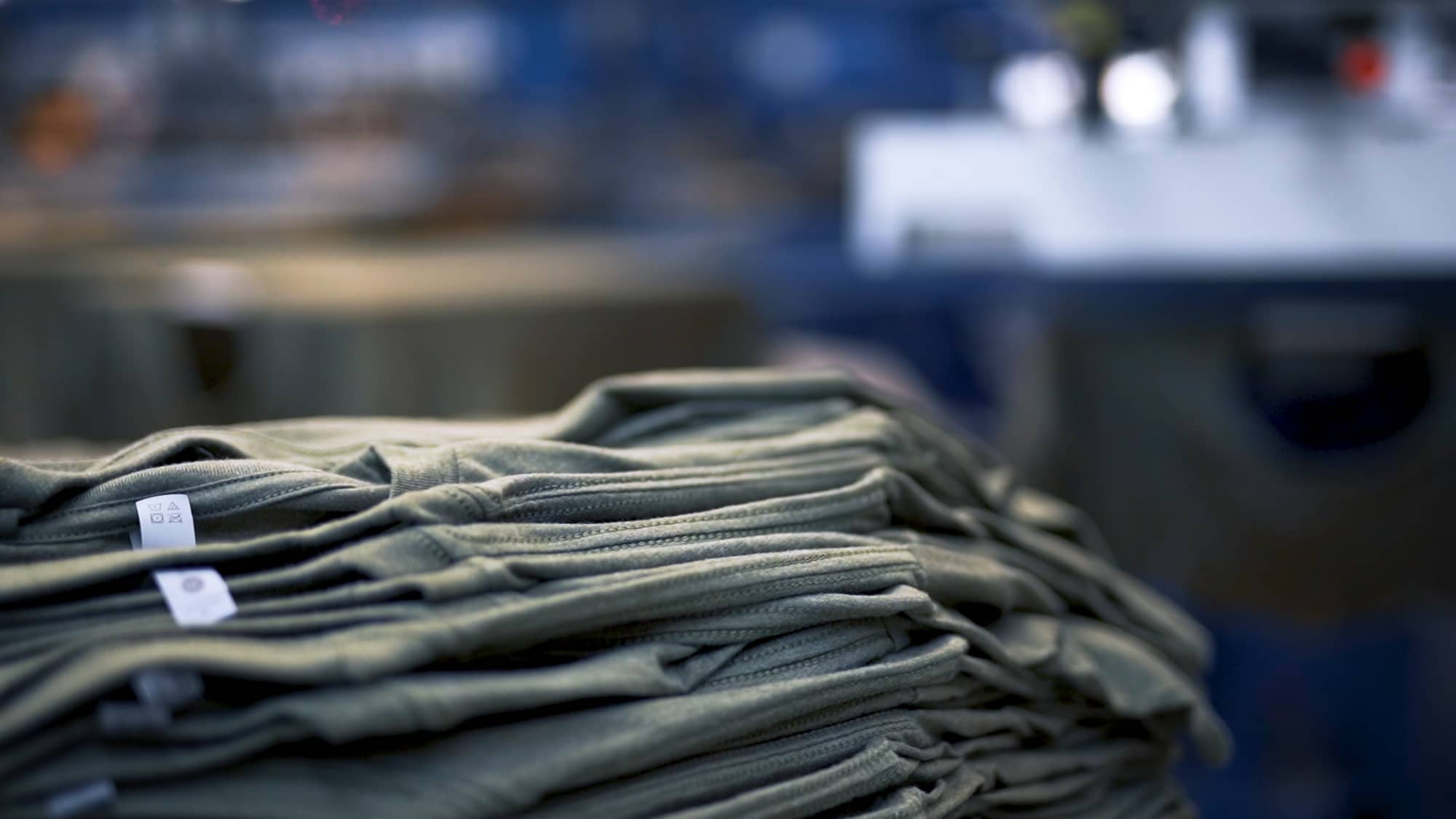 A stack of blank t-shirts prepared to be screen printed.