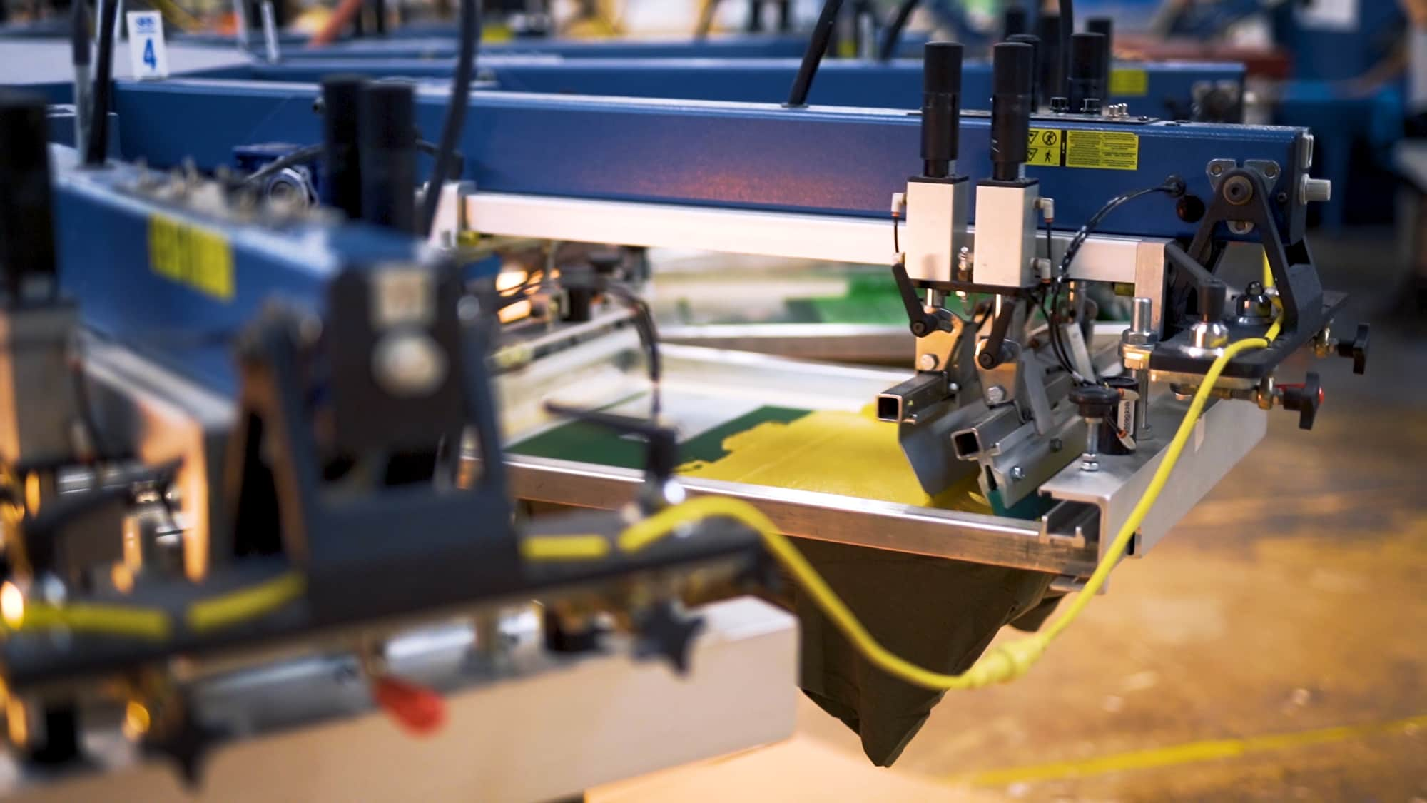 An automatic screen printing press completing a multi-color design.