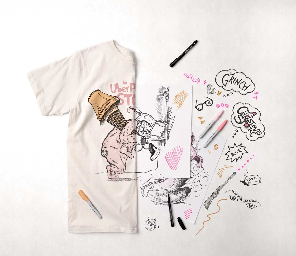 A display of drawing and design materials with the resulting printed t-shirt.