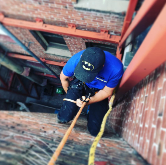 A researching descending down the side of a building.