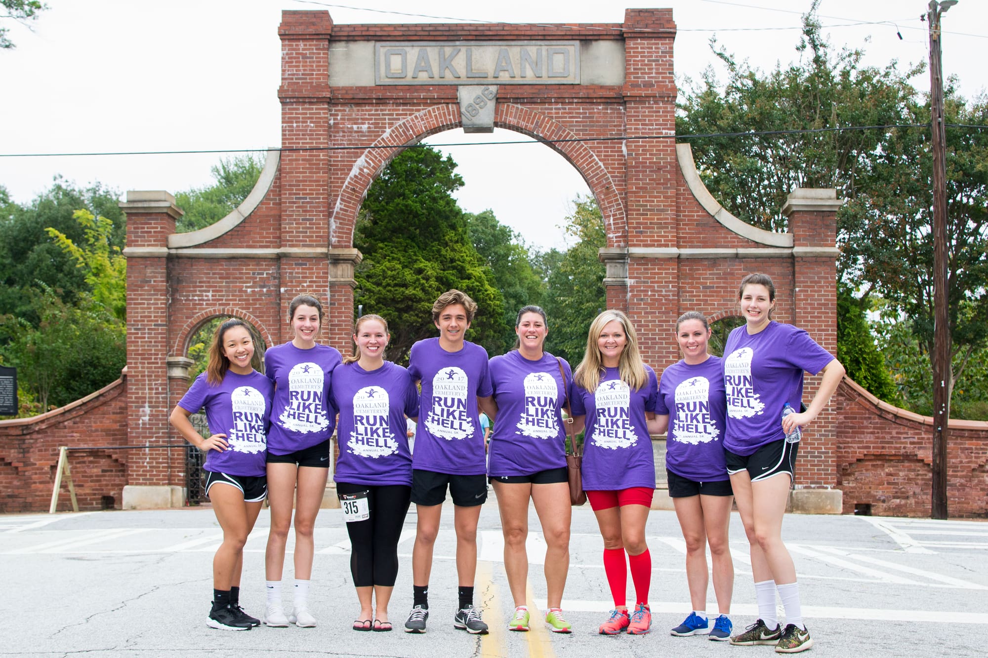 Photo of a group of runners posing while wearing custom 5k t-shirts.