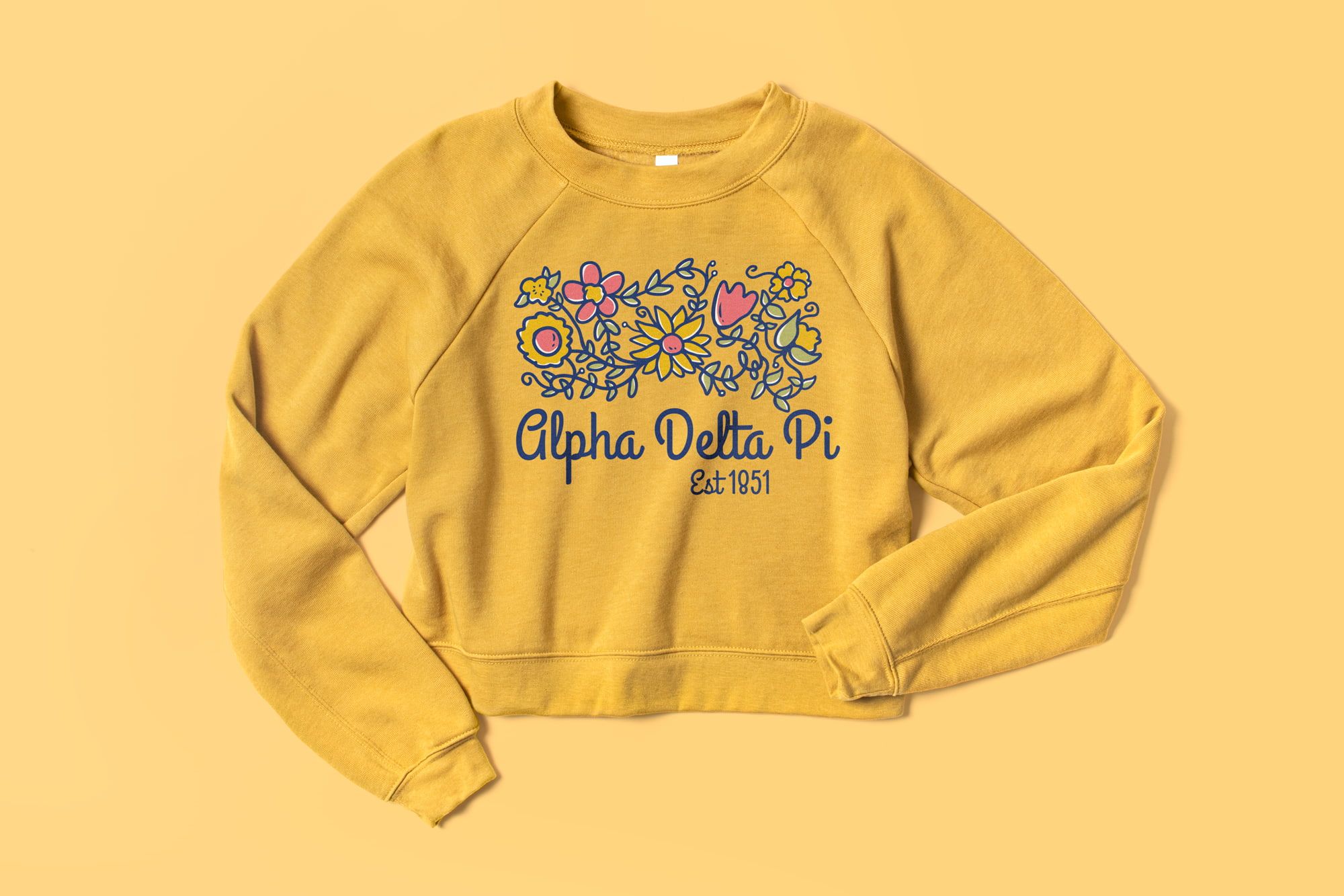 Flatlay of the Bella Canvas Ladies Raglan Cropped Fleece showing a custom sorority design.