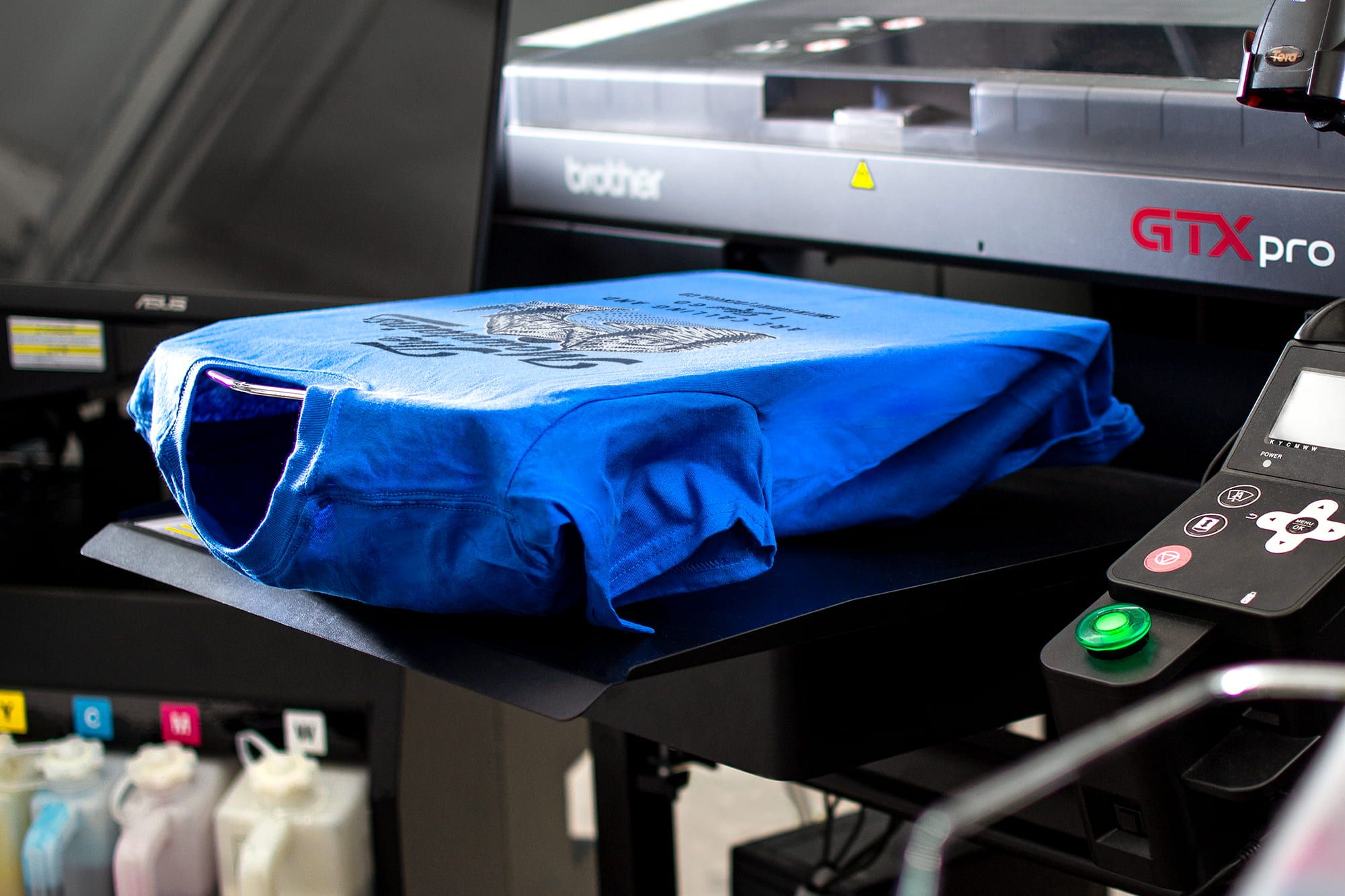 An image showing a single t-shirt being digitally printed for a customer.