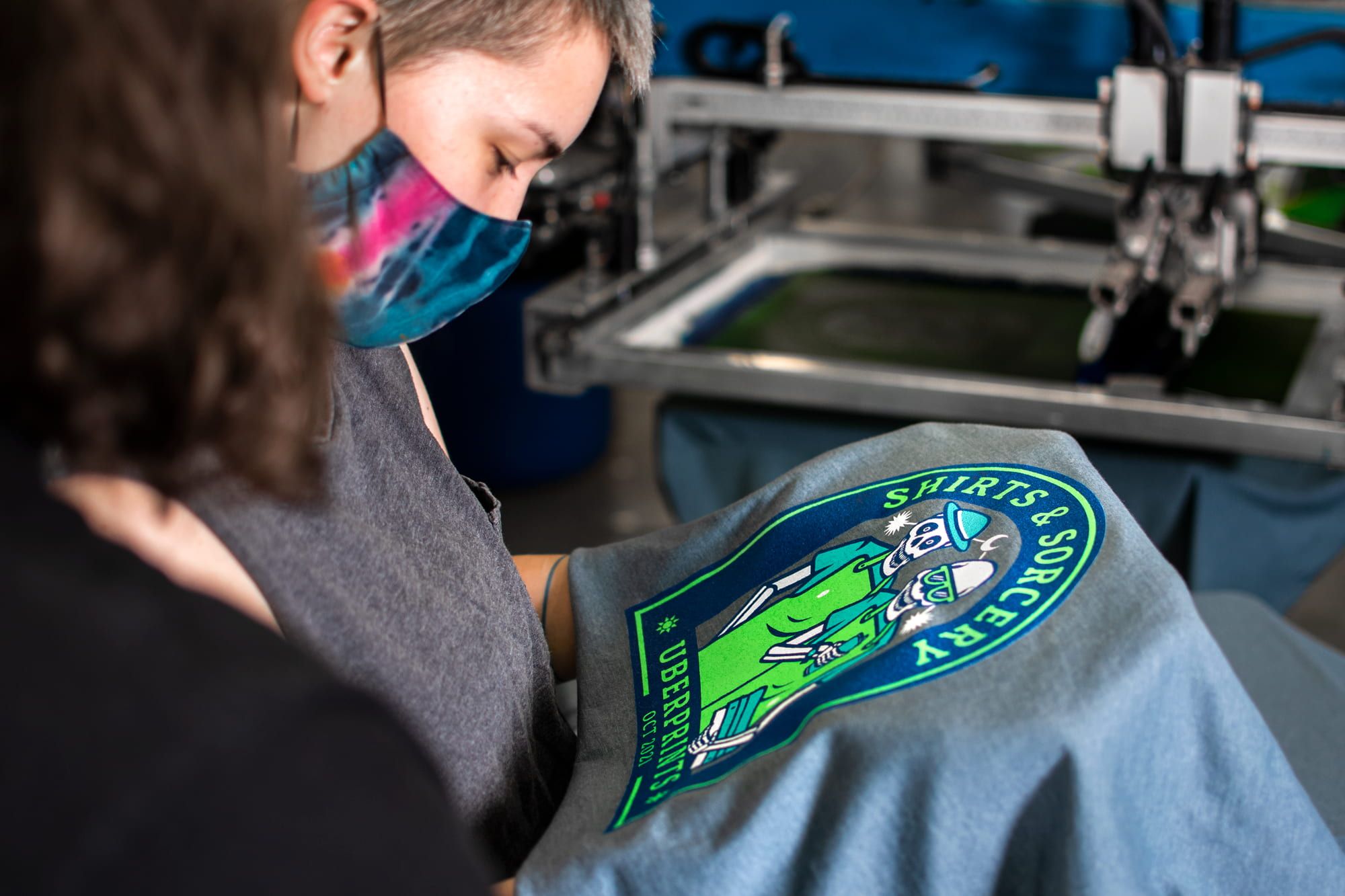 Quality assurance is everyone's job. Pictured are two UberPrints employees checking the Shirts & Sorcery shirt for any printing errors.