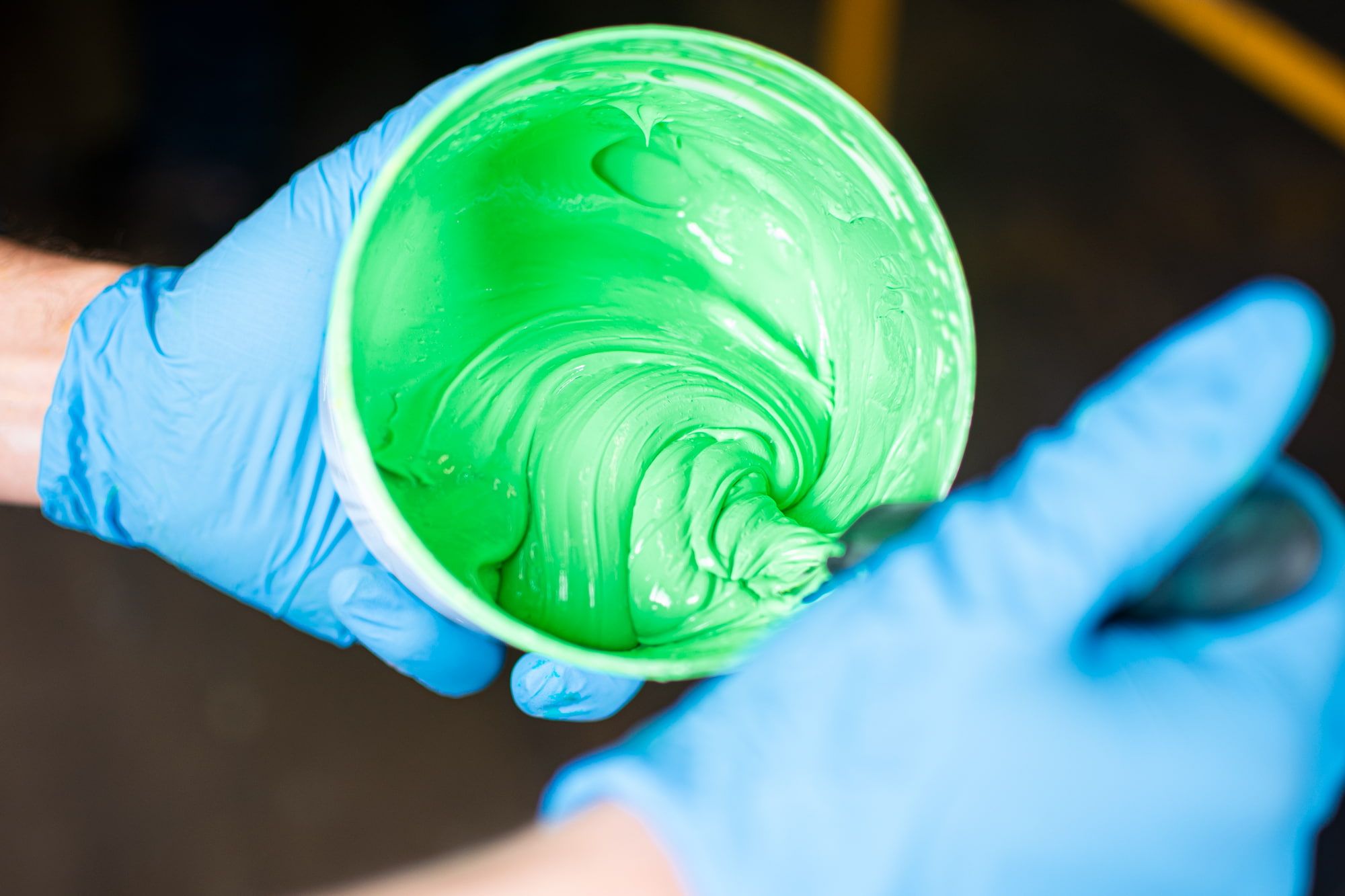 Inks are mixed by hand at UberPrints. Pictured is a close up shot of the ink in the container being swirled around to mix the ink to perfection.