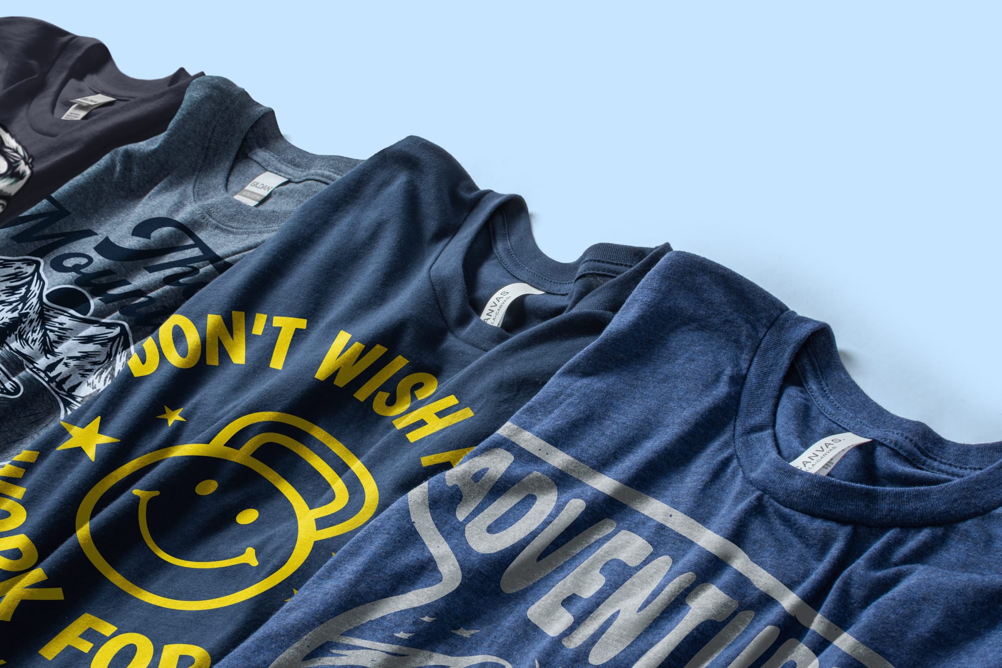 A closeup of navy t-shirts with a variety of designs on the front.