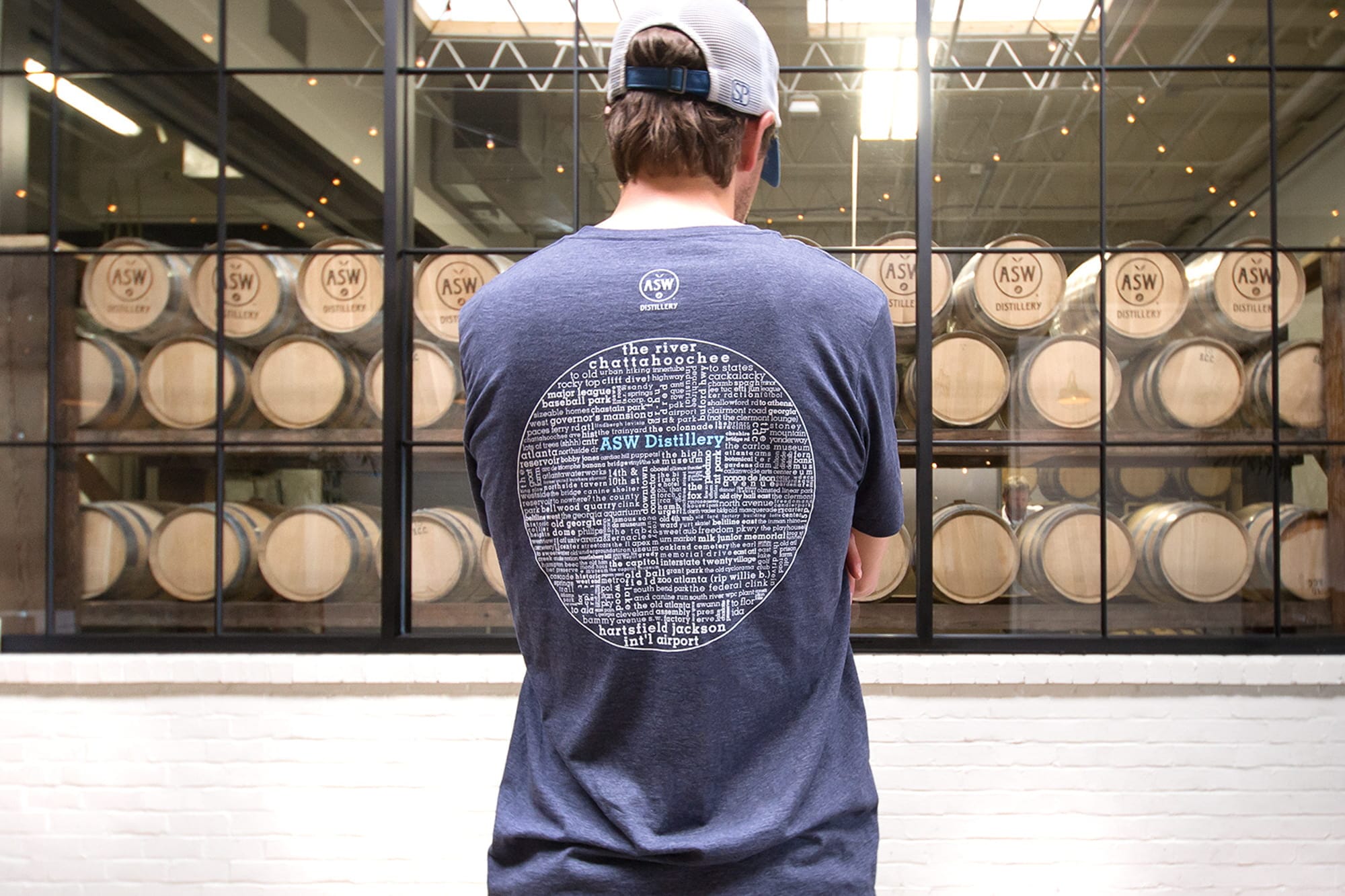 A person wearing a t-shirt for a distillery brand named ASW.