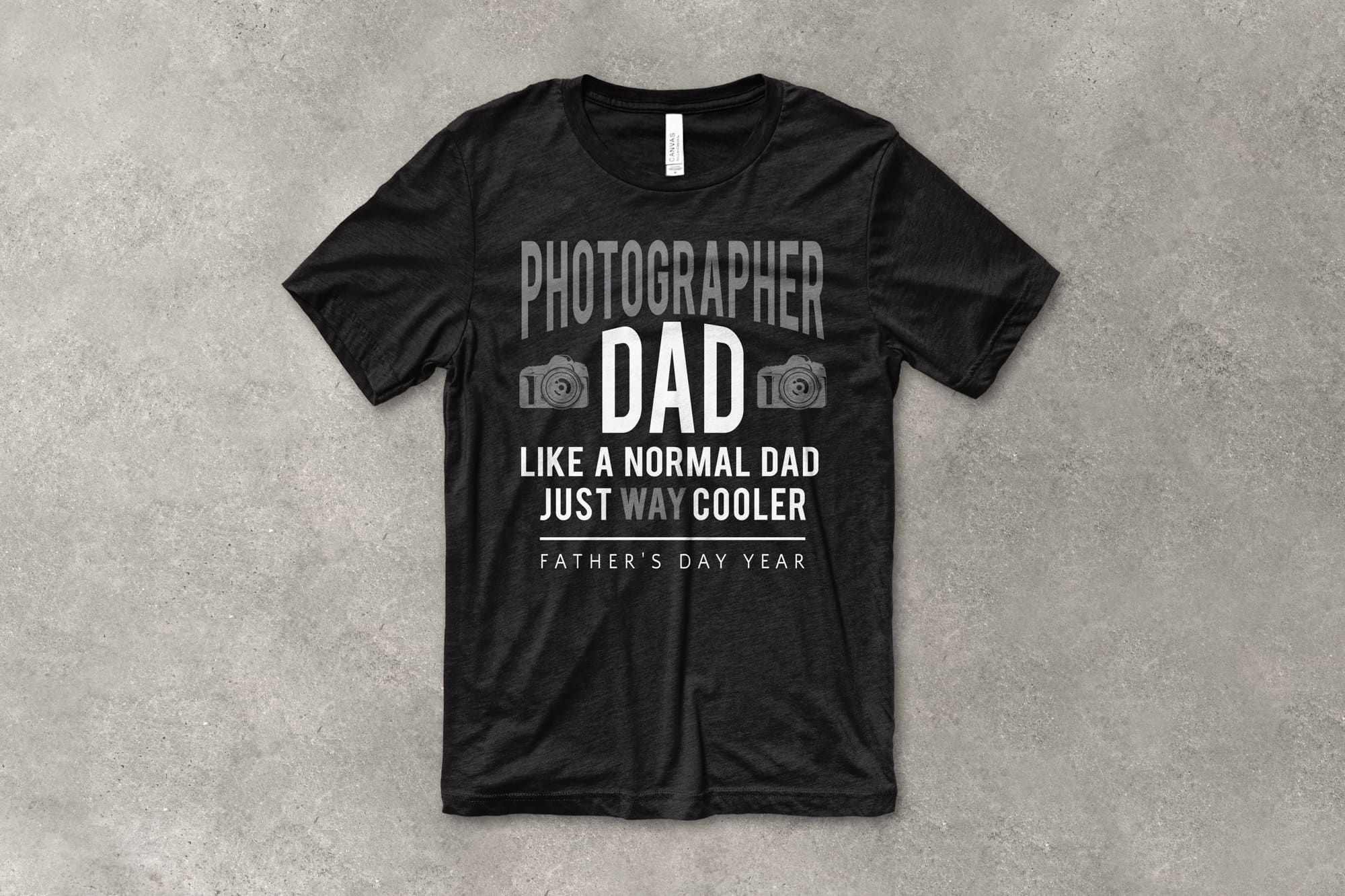 A flat t-shirt that has a customizable design that says "Photographer Dad. Like a Normal Dad,  just way cooler"