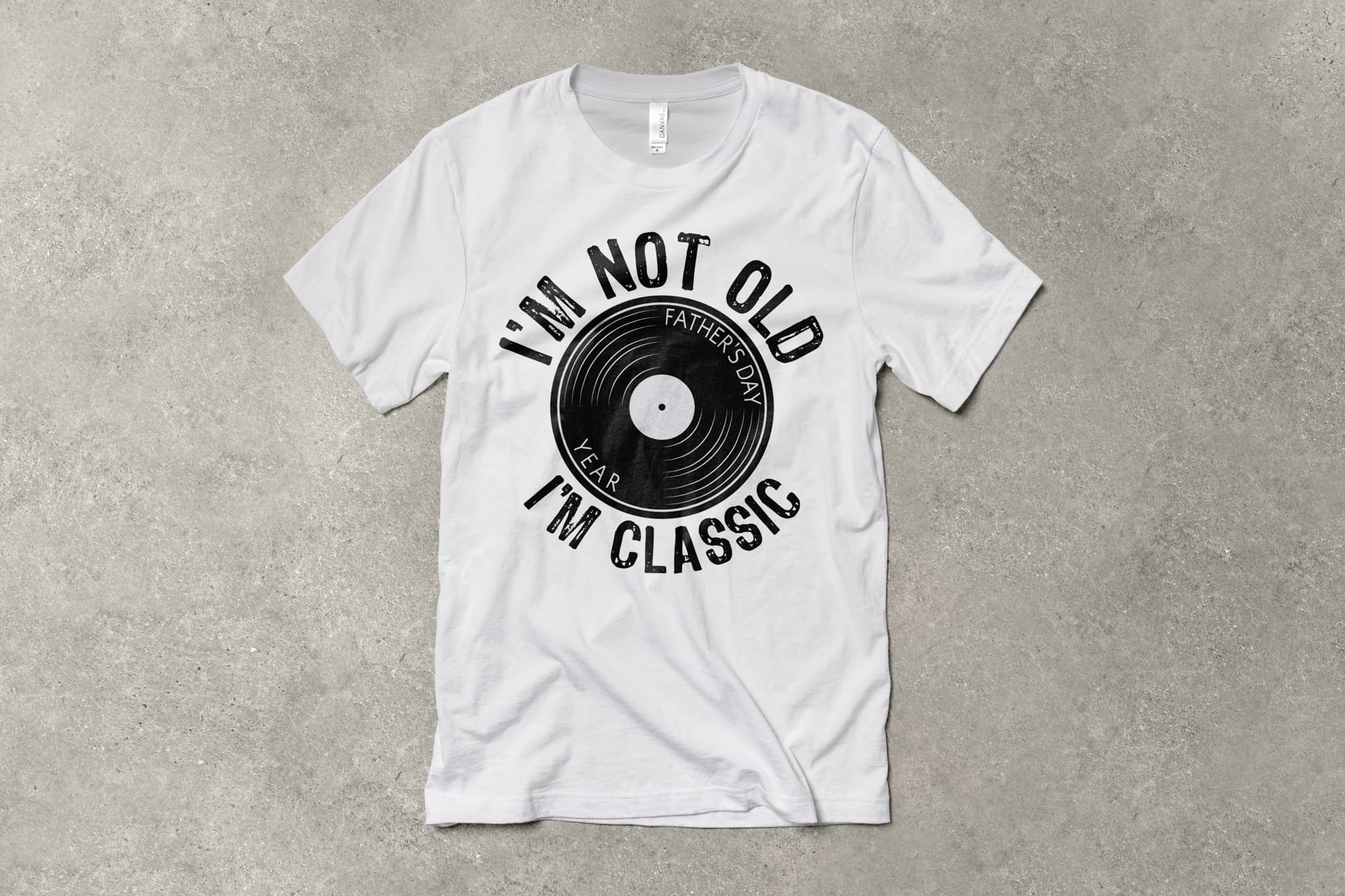 A flat t-shirt that has a customizable design that says "I'm not old, I'm classic" and features a vinyl record.