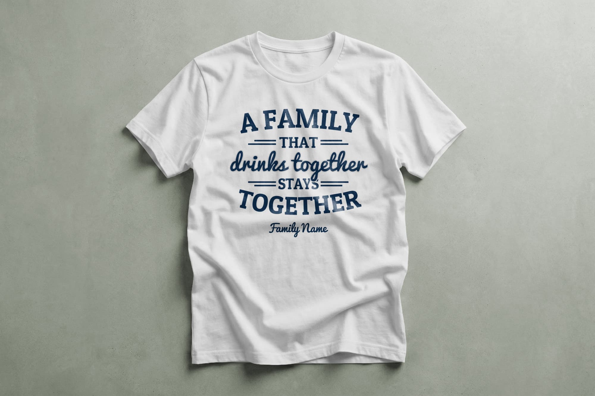 White t-shirt with blue text: "A family that drinks together stays together. Family Name." Casual, humorous design on a flat gray background.