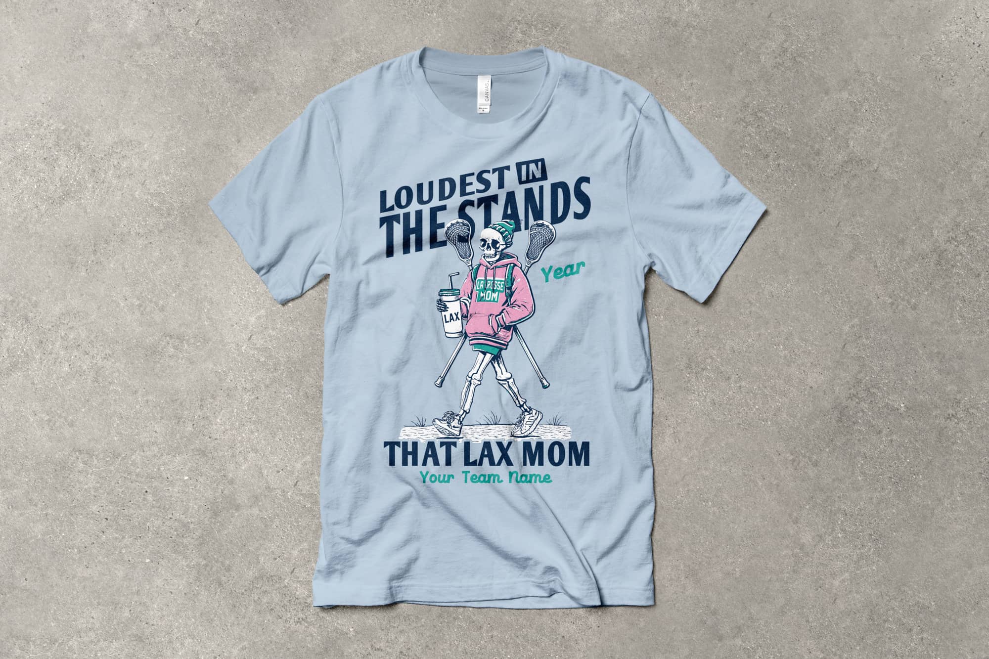 Light gray T-shirt featuring a fun skeleton in a pink hoodie, holding lacrosse sticks. Text reads, "Loudest in the Stands, That Lax Mom." Playful tone.