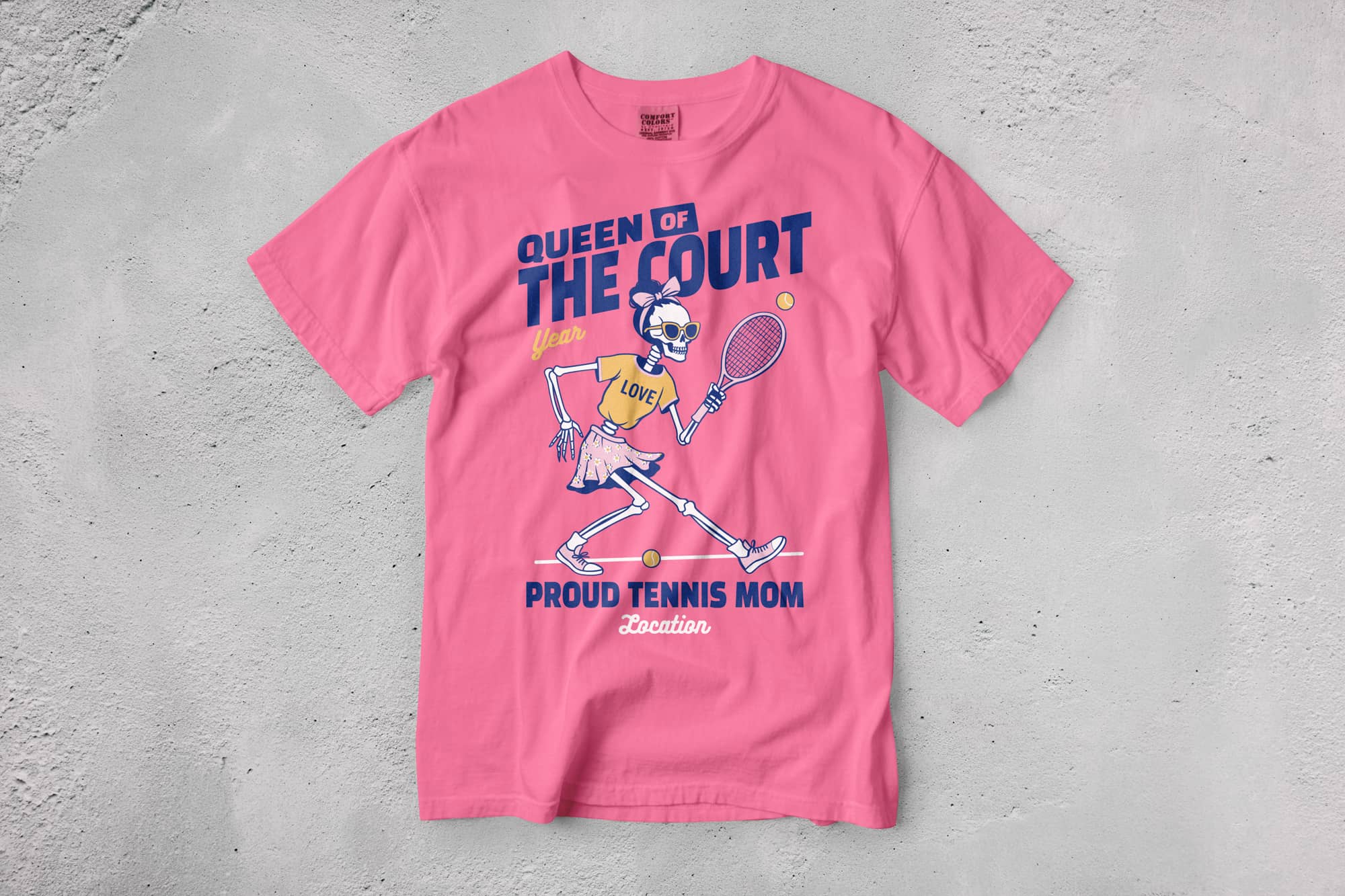 Pink T-shirt with a cartoon skeleton in tennis attire, holding a racket. Text reads "Queen of the Court," expressing playful, sporty enthusiasm.