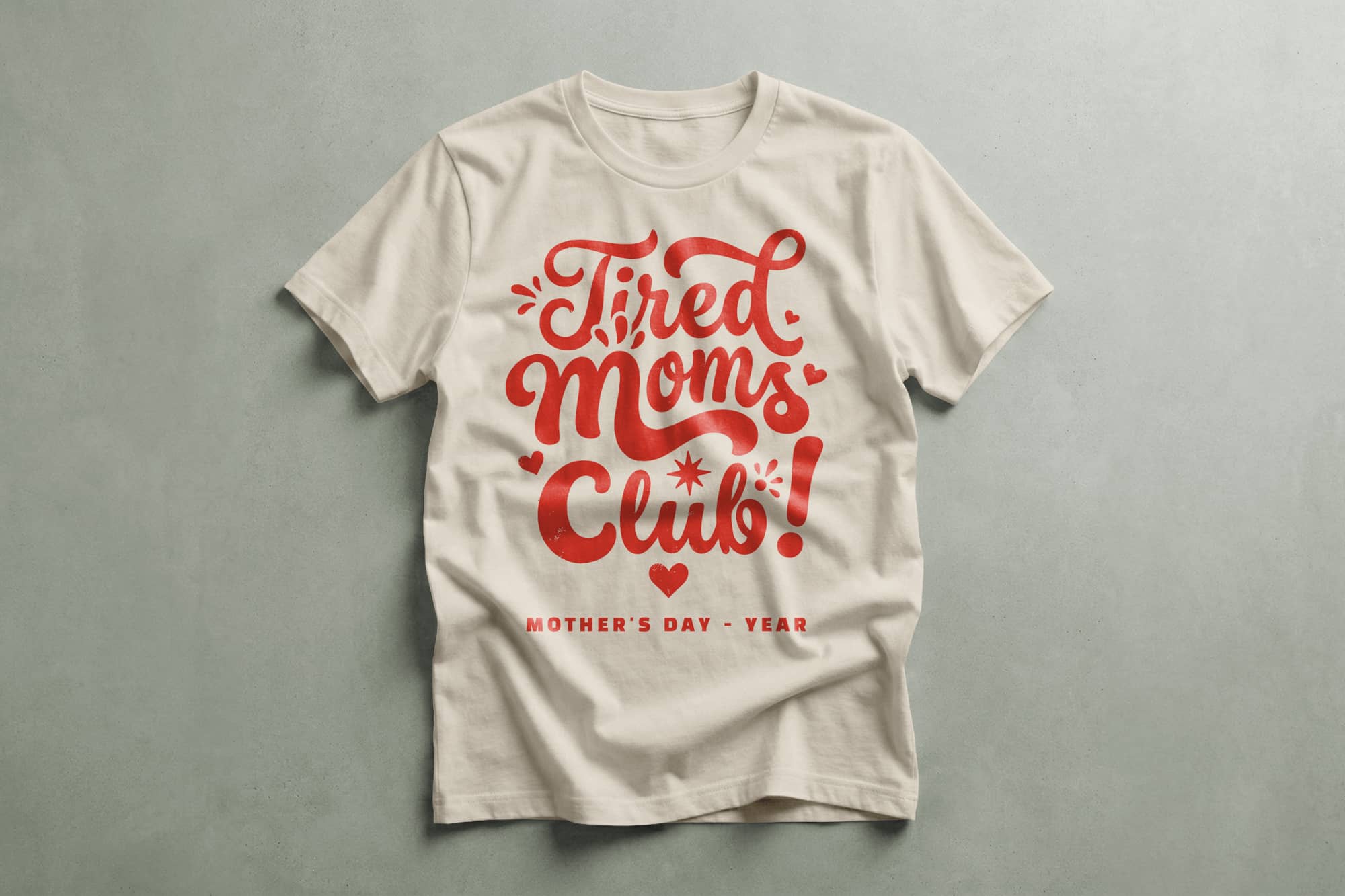 White T-shirt with red script reading "Tired Moms Club!" above "Mother's Day - Year" in smaller text. Design features playful hearts and stars.