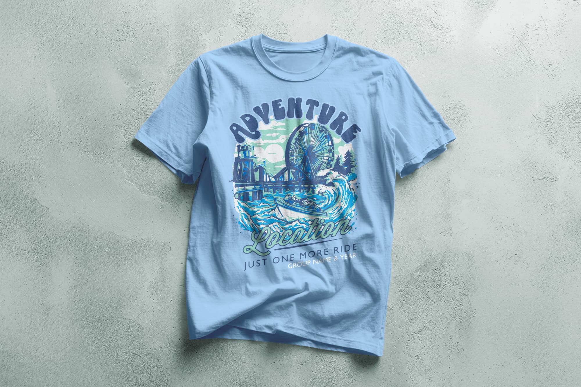 Light blue T-shirt featuring a vintage-style graphic of an amusement park with a Ferris wheel and roller coaster. Text reads "Adventure Location."
