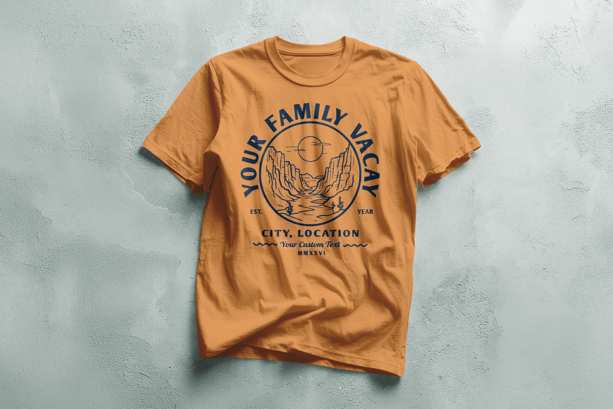 Orange T-shirt with a navy blue design featuring a scenic canyon and sun. Text above reads "Your Family Vacay," with customizable details below. Casual and adventurous tone.